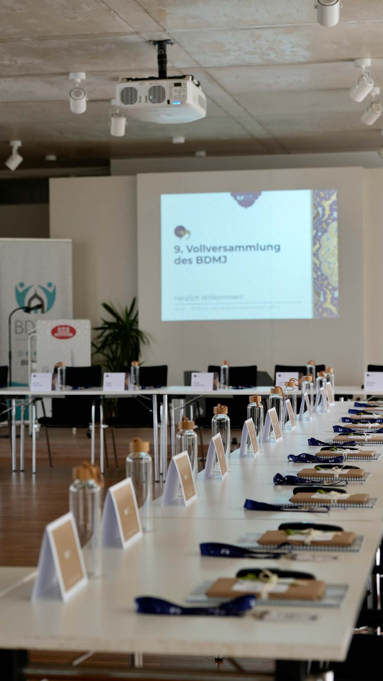 Tagungssaal der 9. Vollversammlung des BDMJ mit Präsentation und Tischset